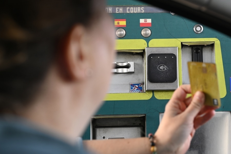 person paying with a bank card at a toll booth